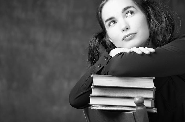 Woman leaning on pile of books