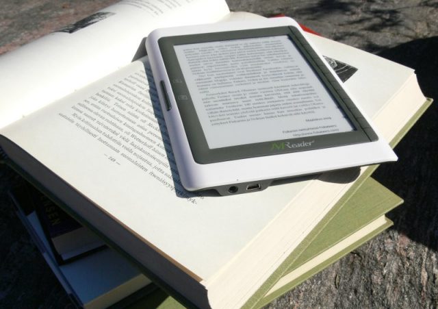 ereader on top of  stack of books