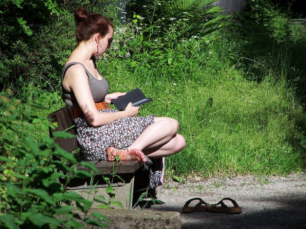 ereader, woman reading on bench, wolf g, flickr