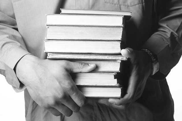 man holding old books in his hands