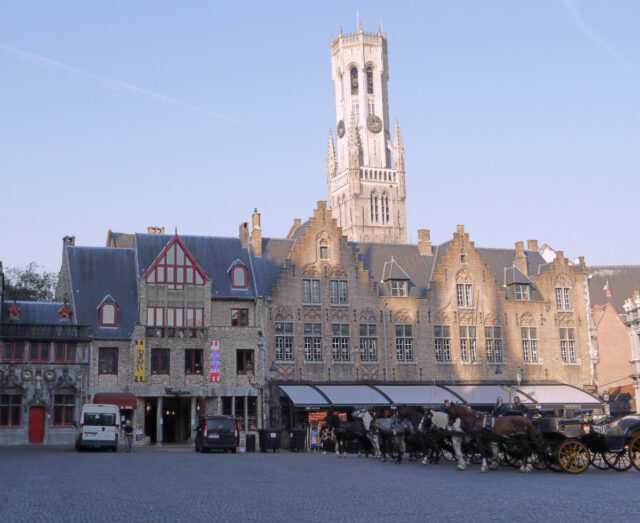 bruges, main square with horse carriage taxis