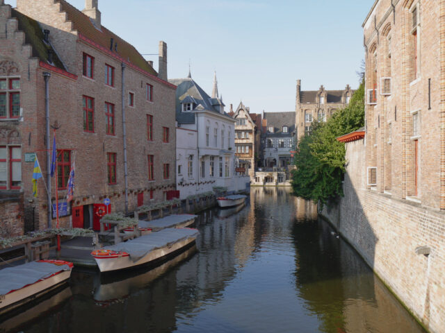 brugge (bruges), canal with boats at house front door