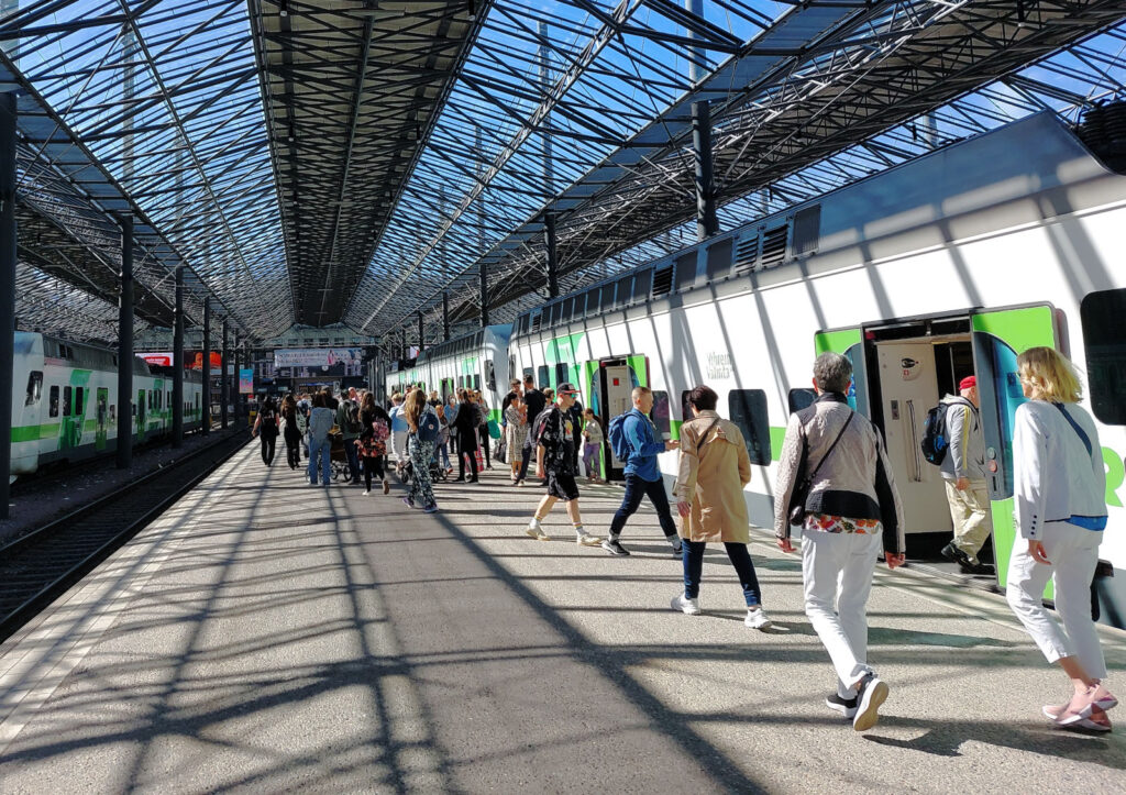 railway station helsinki, finland: passenger leaving and entering a train