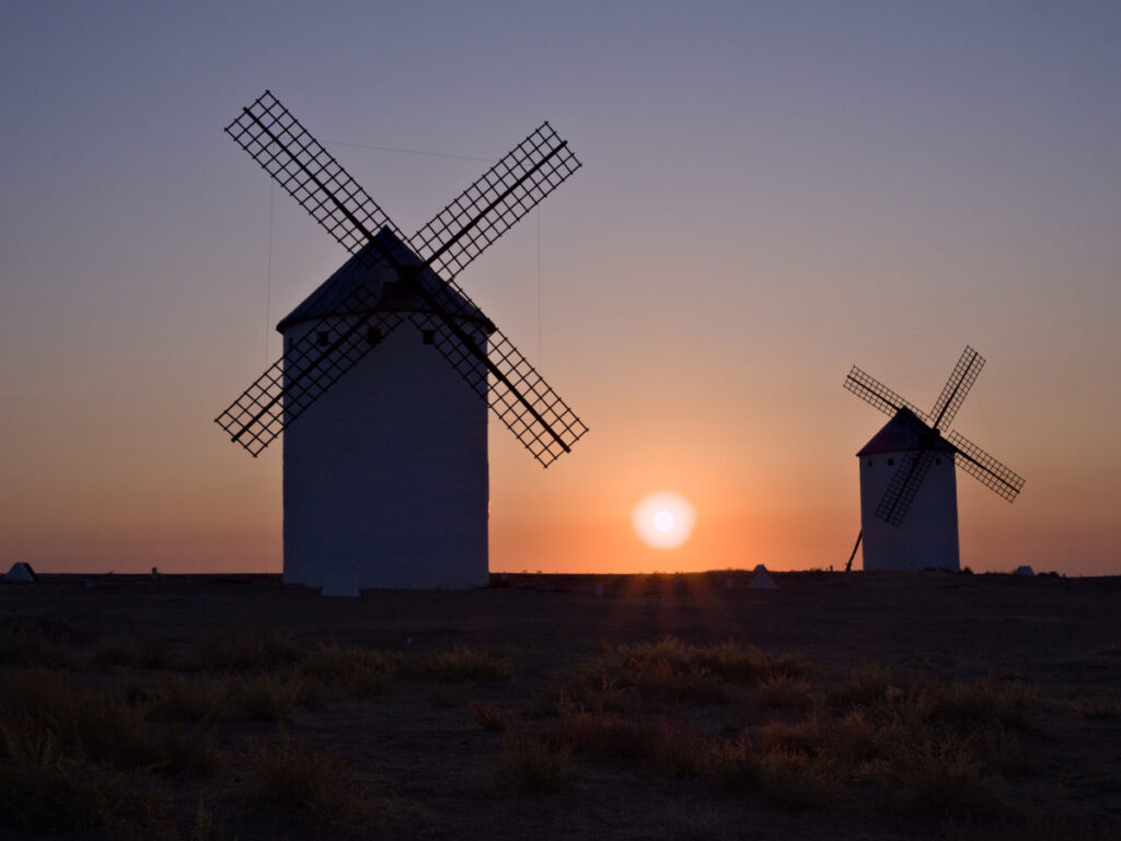 sunrise in campo de criptana, spain among ancient windmills. photo by arihak.