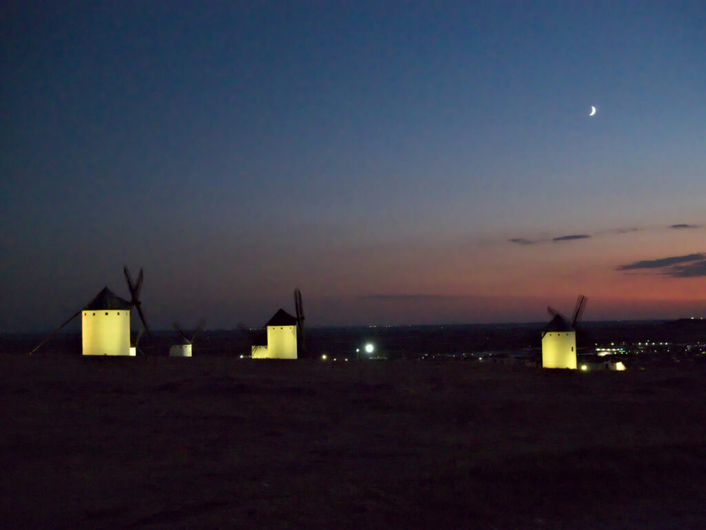 ancient windmills in campo de criptana, spain during sunset. photo by arihak.