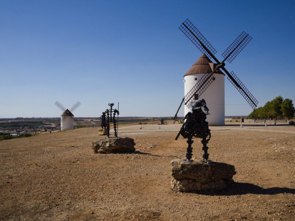 historic windmills and don quijote statue in mote del cuervo, spain.